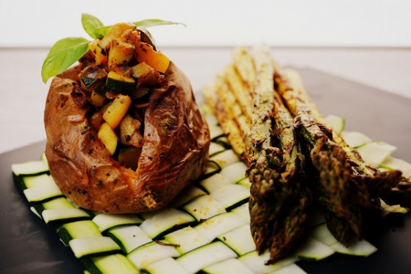 Pieczone bataty nadziewane warzywami podane z grillowanymi szparagami