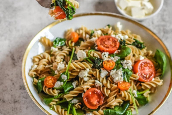 Makaron z serem feta, szpinakiem i pomidorkami koktajlowymi