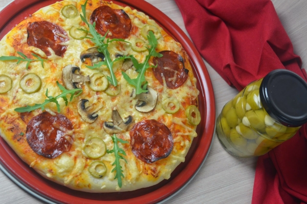 Pizza z oliwkami, chorizo i świeżą rukolą