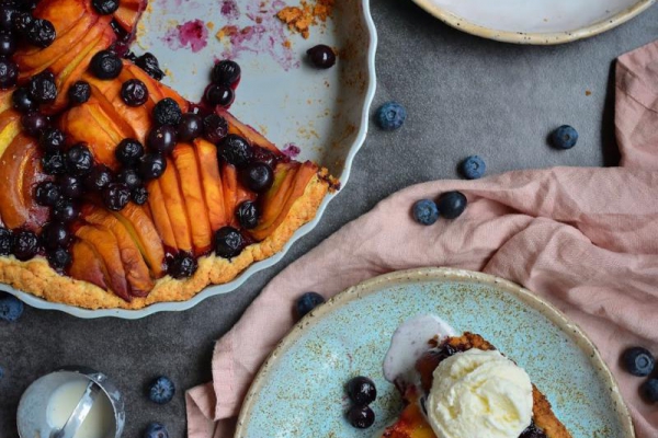 Tarta na kruchym spodzie z brzoskwiniami, borówkami i lodami waniliowymi.