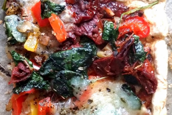Pizza z mocarellą, szpinakiem, suszonymi pomidorami i papryką