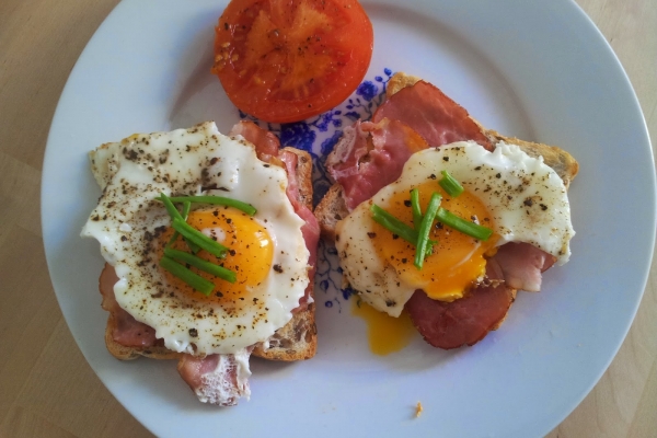 Ciepłe śniadanie na słono: tost z bekonem, sadzonym jajkiem i pomidorem