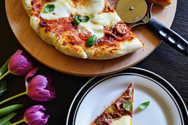 Domowa pizza z szynką i pomidorami koktajlowymi.