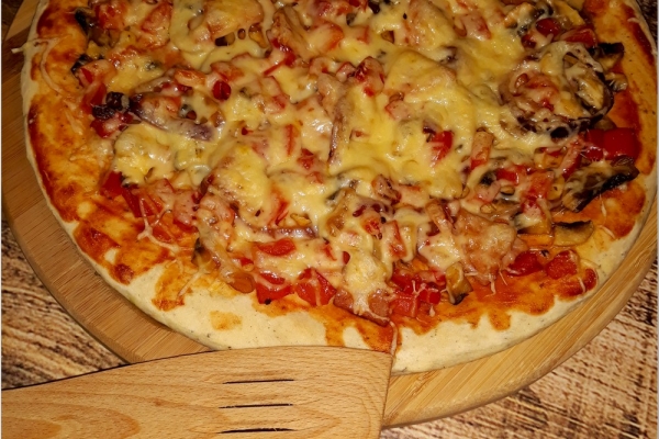 Domowa pizza na cieście z dodatkiem suszonej bazylii
