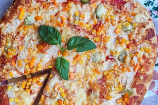 Domowa pizza z kukurydzą, kurczakiem, papryką i ogórkiem