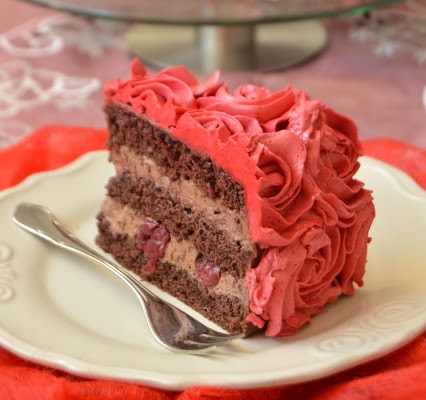 Tort czekoladowy z wiśniami i dekoracją z kremu maślanego na bezie szwajcarskiej