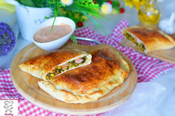 Calzone z kiełbasą w towarzystwie szpinaku i kolorowych warzyw