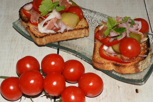 Bruschetta z prosciutto, ogórkiem kiszonym i pomidorkami cherry