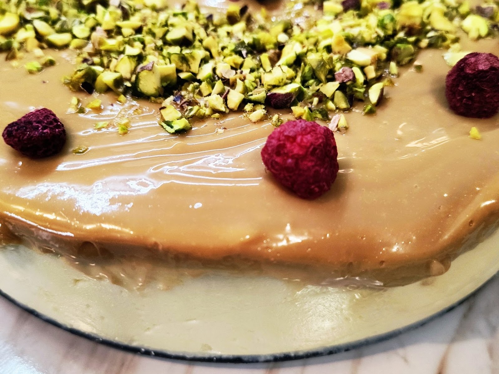Sernik z masą kajmakową, pistacjami i malinami