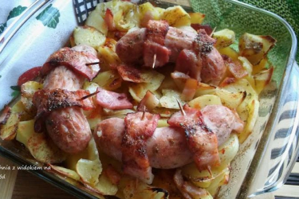 Biała kiełbasa z piekarnika, pieczona z ziemniakami, boczkiem i cebulą.