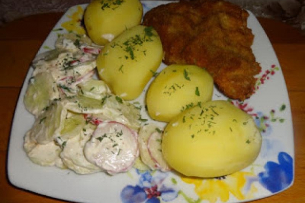 Kotlet schabowy z młodymi ziemniakami i mizerią z ogórka i rzodkiewki.
