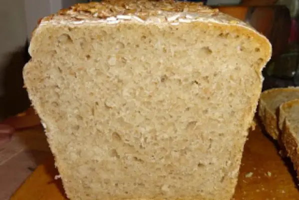 Chleb pszenny na żytnim zakwasie posypany płatkami owsianymi.