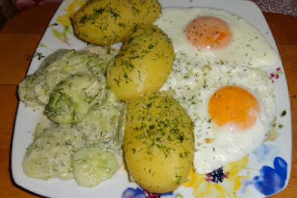 Młode ziemniaki, jajka sadzone, mizeria z ogórków.