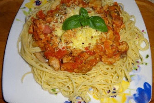 Sos boloński z makaronem spaghetti i żółtym serem.