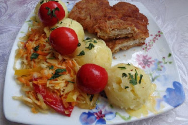 Kotlet schabowy z ziemniakami i sałatka warzywna.