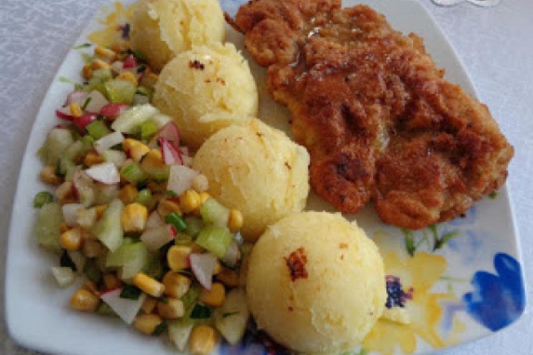 Kotlet schabowy z ziemniakami i surówką z selera naciowego.