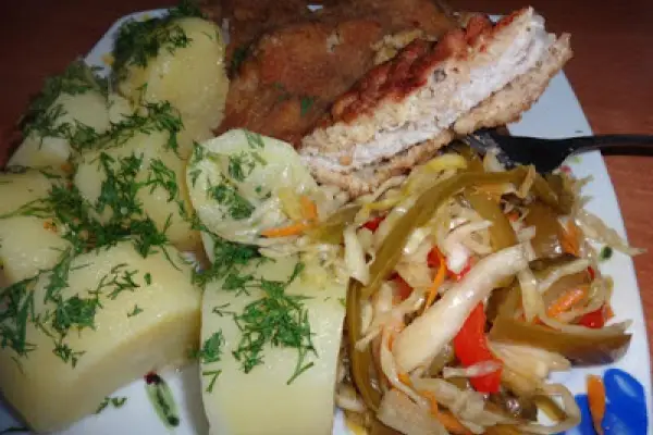 Schabowy, ziemniaki i sałatka z papryk.
