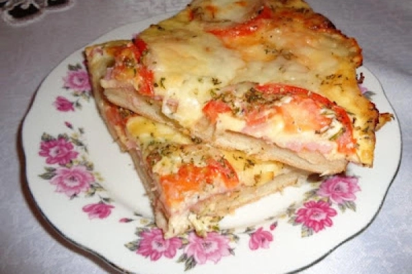 Pizza z szynką, serem i pomidorem.