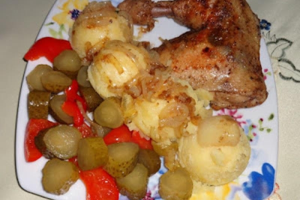 Smażone udka z kurczaka, ziemniaki i marynowane ogórki z papryką.
