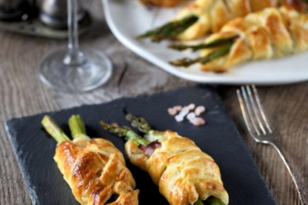 Szparagi zapiekane w cieście francuskim z szynką parmeńską i mozzarellą.