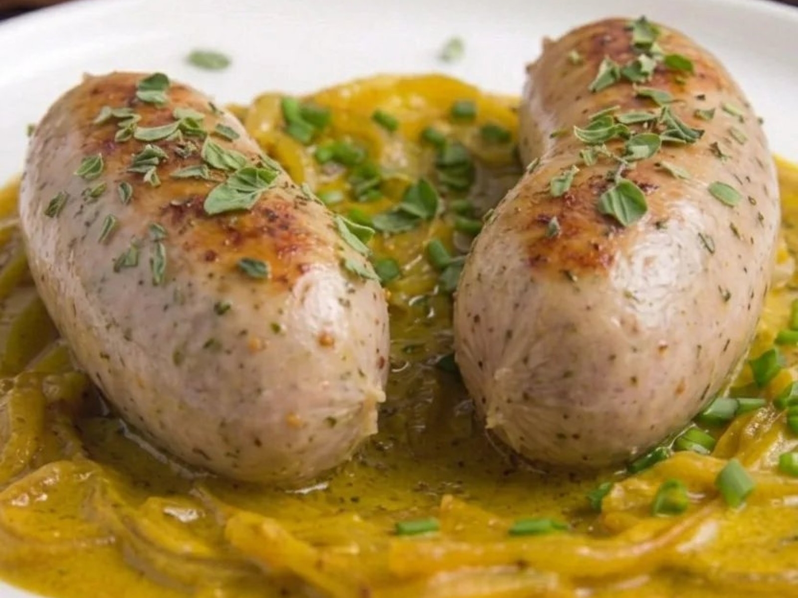 Biała kiełbasa surowa pieczona w piekarniku z cebulą